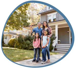 An immigrant family granted permanent residency in Canada, standing in front of their newly-acquired house.